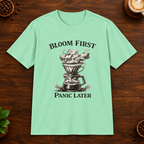 Bloom First T-Shirt in Mint Green on a wooden coffee-themed background