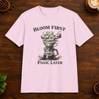 Bloom First T-Shirt in Light Pink on a wooden coffee-themed background