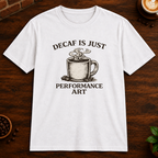 Decaf is Just Performance Art T-Shirt in White, close-up on dark wood coffee bar