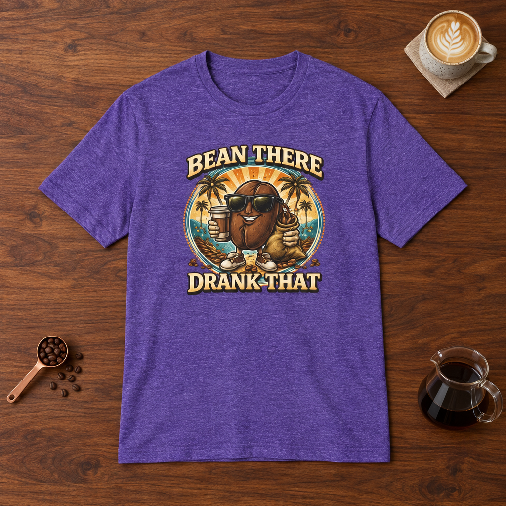 Bean There Drank That T-Shirt Heather Purple flat lay on walnut coffee bar