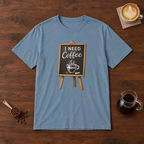 I Need Coffee T-Shirt Stone Blue flat lay on walnut coffee bar