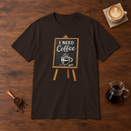 I Need Coffee T-Shirt Dark Chocolate flat lay on walnut coffee bar